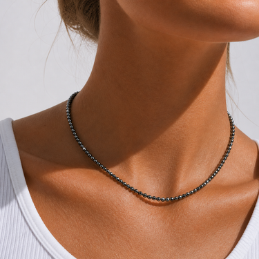 Amelty Necklace dark faceted beaded necklace worn on model with minimalist neckline styling.