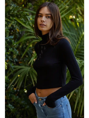 Amit Top black turtleneck fitted crop top side view showing long sleeves and sculpted fit