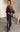 Woman wearing sheer black Ammica Maxi Dress with beaded details indoors under soft light.