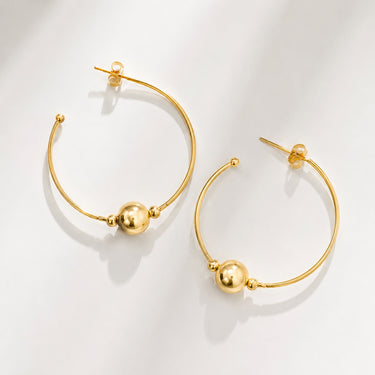 Anya Hoop Earrings featuring polished gold-plated open hoop earrings with floating gold bead accents, slim rounded silhouette, mirror finish, secure post-back closure, lightweight design, and modern statement style, displayed on a soft white background.