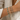Model wearing multiple Arinet Bracelets stacked together, featuring adjustable cords, freshwater pearls, polished gold beads, and bead accents styled on the wrist.