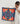 Aspen Scarf with navy background and orange geometric print, held by model in white dress, art-inspired square scarf for Matte.