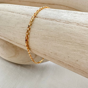 Atela Bracelet gold plated square link chain displayed on wood bar