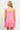 Model wearing pink Gingham Eyelet Dress with floral embroidery and ruffled hem, back view