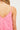 Model wearing pink Gingham Eyelet Dress with floral embroidery and ruffled hem.