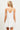 Model wearing white Gingham Eyelet Dress with floral embroidery and ruffled hem, back view