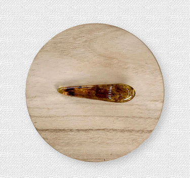 Bobby Hair Clip in carey resin on light wood background, by Matte.