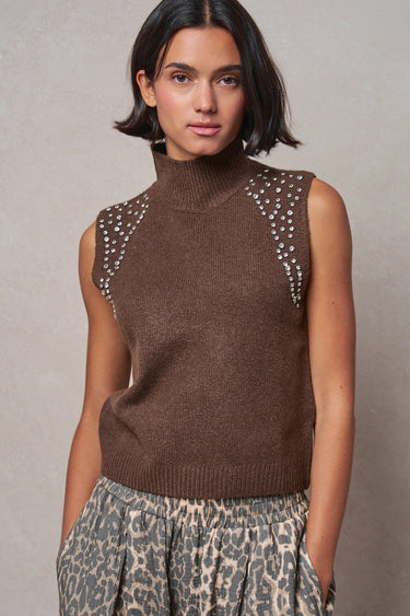 Woman wearing the Boon sleeveless mock-neck knit top in brown with crystal shoulder embellishments and a relaxed fit.