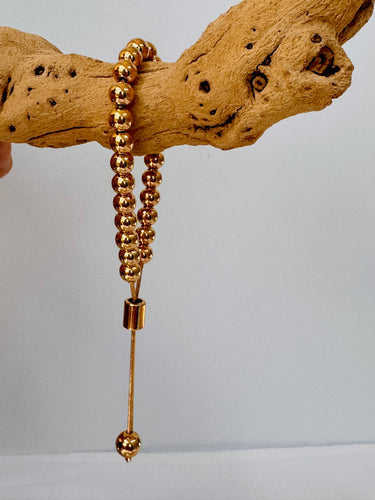 Buda Bracelet gold adjustable beaded bracelet on wood display by Matte