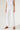 Model wearing Camelia Jeans in white high-rise wide-leg fit.