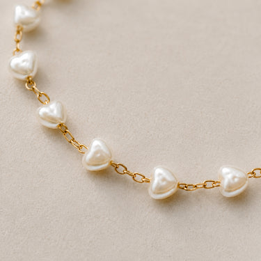Close-up of the Carroll gold necklace with heart-shaped freshwater pearls.