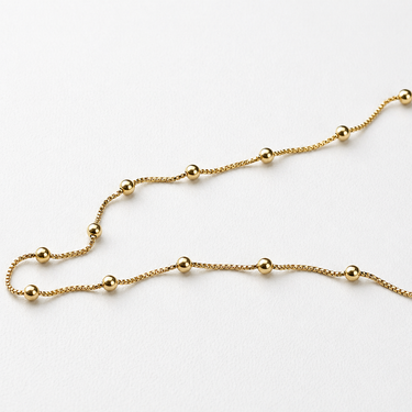 Ceketi Necklace delicate gold filled station necklace with polished bead accents on chain.