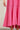 Close up of model wearing Ainsley Pink Midi Dress with ruffled hem and thin straps.