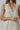 Model wearing natural linen Ezeiza Dress with fringed V-neckline.