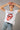 Model wearing the Electric Soul Shirt — white vintage graphic tee with red Rolling Stones tongue design, styled with relaxed jeans and black belt, close up.