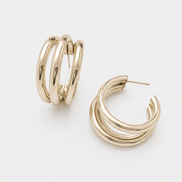 Collete Hoop Earrings featuring polished gold-plated triple-band hoop earrings with a layered stacked-hoop design, rounded high-shine finish, lightweight construction, secure hinged closure, and a bold yet timeless silhouette.