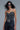 Black corset top with sparkling crystal design, styled with chunky belt and jeans.