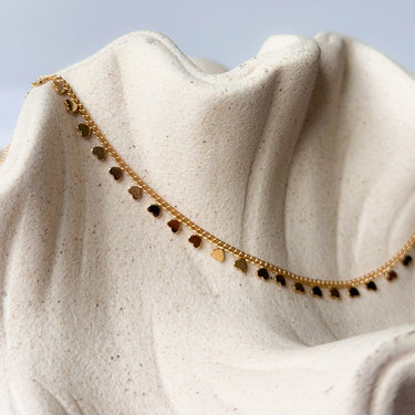 Dalia necklace silver plated heart charm chain on textured beige background