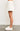 Model wearing white textured floral mini skirt with sneakers — modern and feminine summer look, side view.