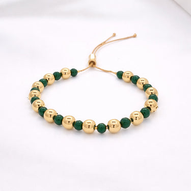 Darcity Beaded Bracelet gold bead bracelet with green stone accents adjustable cord style on neutral background showing polished beads and delicate spacing.