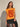 Model wearing the Drumar Graphic Tee in mustard yellow featuring the bold red snake graphic, crew neckline, structured cap sleeves, and relaxed cropped silhouette paired with black bottoms.