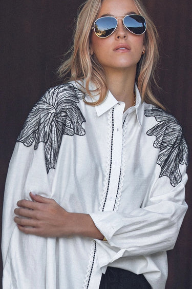 Elaine Shirt oversized white button-front shirt with black embroidered shoulder detailing worn by model.