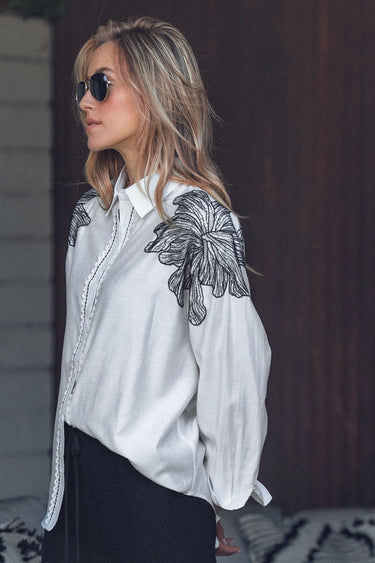 Elaine Shirt side view showing relaxed oversized fit and embroidered flower sleeve details.