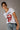 A female model wearing a white graphic tee with a red and black design of lips and a tongue.
