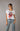 Model wearing the Electric Soul Shirt — white vintage graphic tee with red Rolling Stones tongue design, styled with relaxed jeans and black belt.