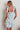 Model in blue floral Ender Mini Dress showing lightweight cotton fabric and tie straps, back view.