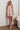 Model wearing orange floral Ender Mini Dress with tie straps and relaxed A-line fit.