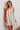 A woman wearing a floral mini dress with tied shoulder straps.