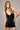Woman wearing the Ephesus Bodysuit in black with bold metallic embroidery and a fitted V-neck silhouette, photographed in soft natural light on a neutral backdrop.