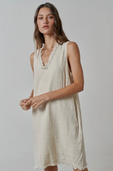Model wearing natural linen Ezeiza Dress with fringed V-neckline.