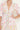 Woman wearing a floral dress with a plain background close up