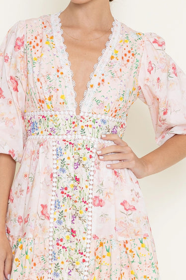 Woman wearing a floral dress with a plain background close up