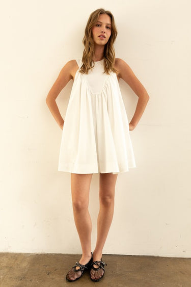 Model wearing Nara Mini Dress in white with halter neckline and relaxed fit.