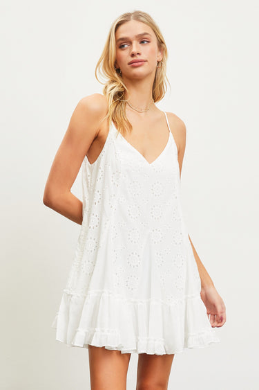 Model wearing white Gingham Eyelet Dress with floral embroidery and ruffled hem.