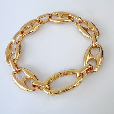 Gold oval link bracelet with polished finish and cubic zirconia accents on clasp link