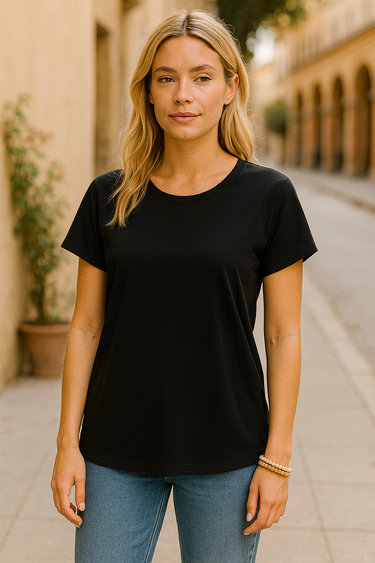 Model wearing the Gustavia T-Shirt — black cotton short-sleeve tee with classic round neckline, styled with jeans outdoors in natural light.