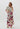A model wearing floral print Hibiscus Pants with an elastic waistband and side pockets, paired with a beige spaghetti strap top.
