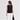 Back view of woman wearing the Hotflix sleeveless denim top styled with white wide-leg pants.
