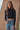 Ikara Top fitted long sleeve top in black styled with denim jeans.
