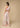 Pastel geometric wide-leg pants styled with matching top, resort-inspired look by the sea, back view.