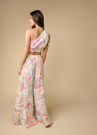 Pastel geometric wide-leg pants styled with matching top, resort-inspired look by the sea, back view.