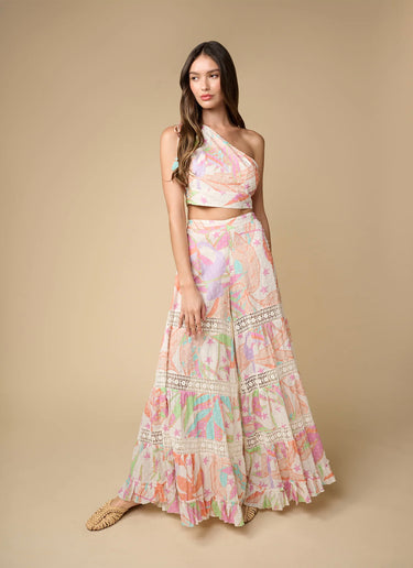 Pastel geometric wide-leg pants styled with matching top, resort-inspired look by the sea.