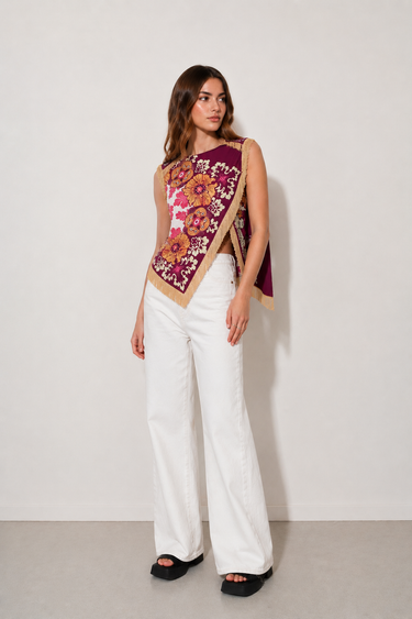 Kirby Top colorful floral scarf-style top with fringe trim styled with white wide-leg pants front view.