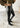 Side view of Kuta Skinny Pants in black with foil finish and fitted silhouette.
