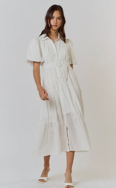 A model wearing a white short-sleeved dress with a button-down front and a flattering waist tie.