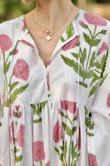 Woman wearing Lissandra Maxi Dress with pink and green floral print walking outdoors in garden setting close up